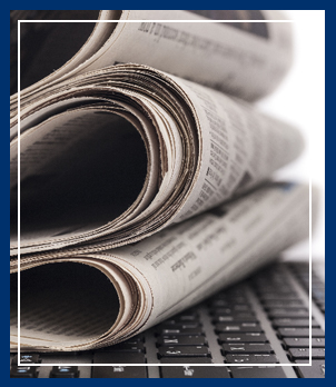 Stack of newspapers on top of a laptop keyboard